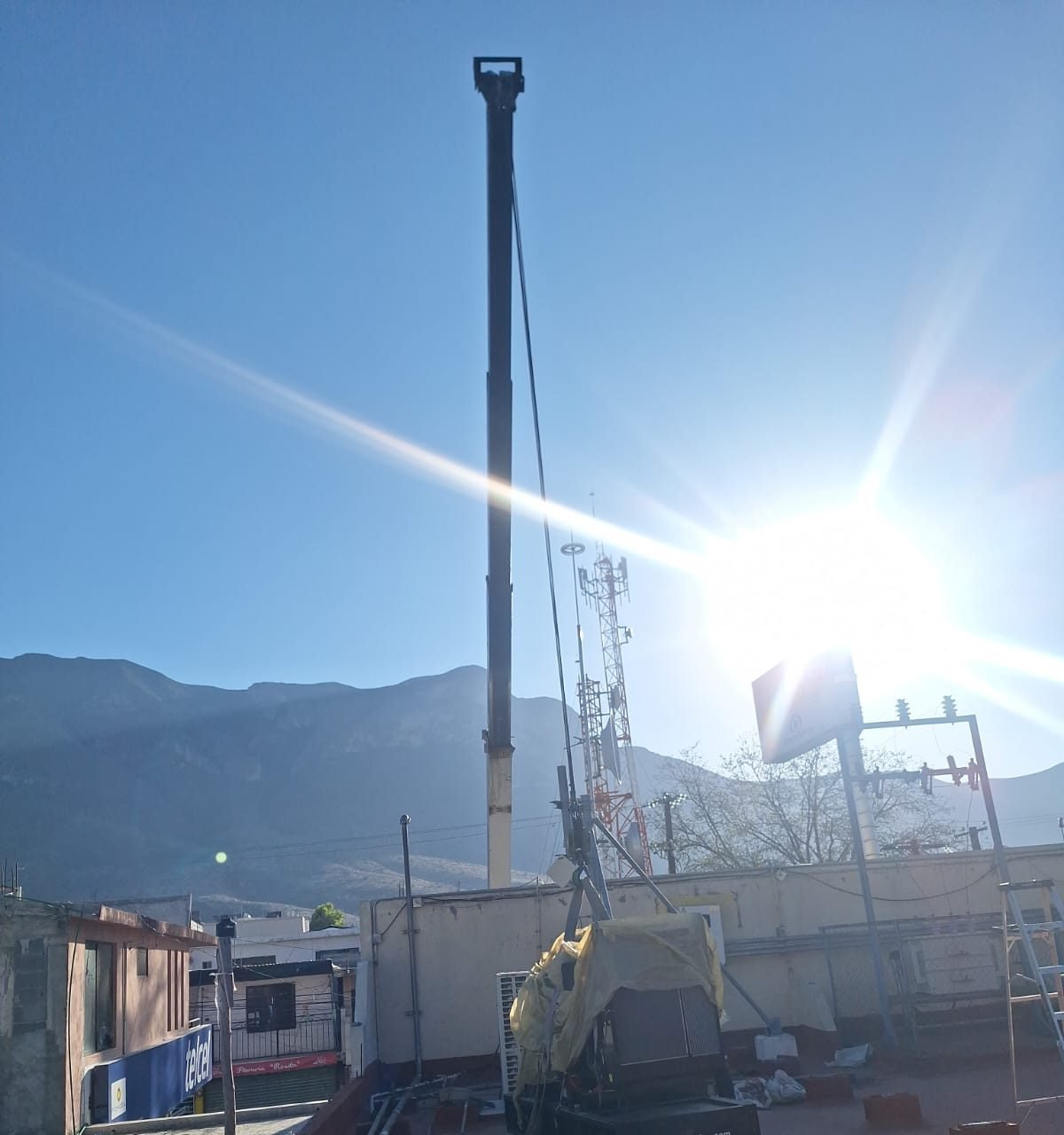 Grúa izando un generador hacia la azotea durante una instalación